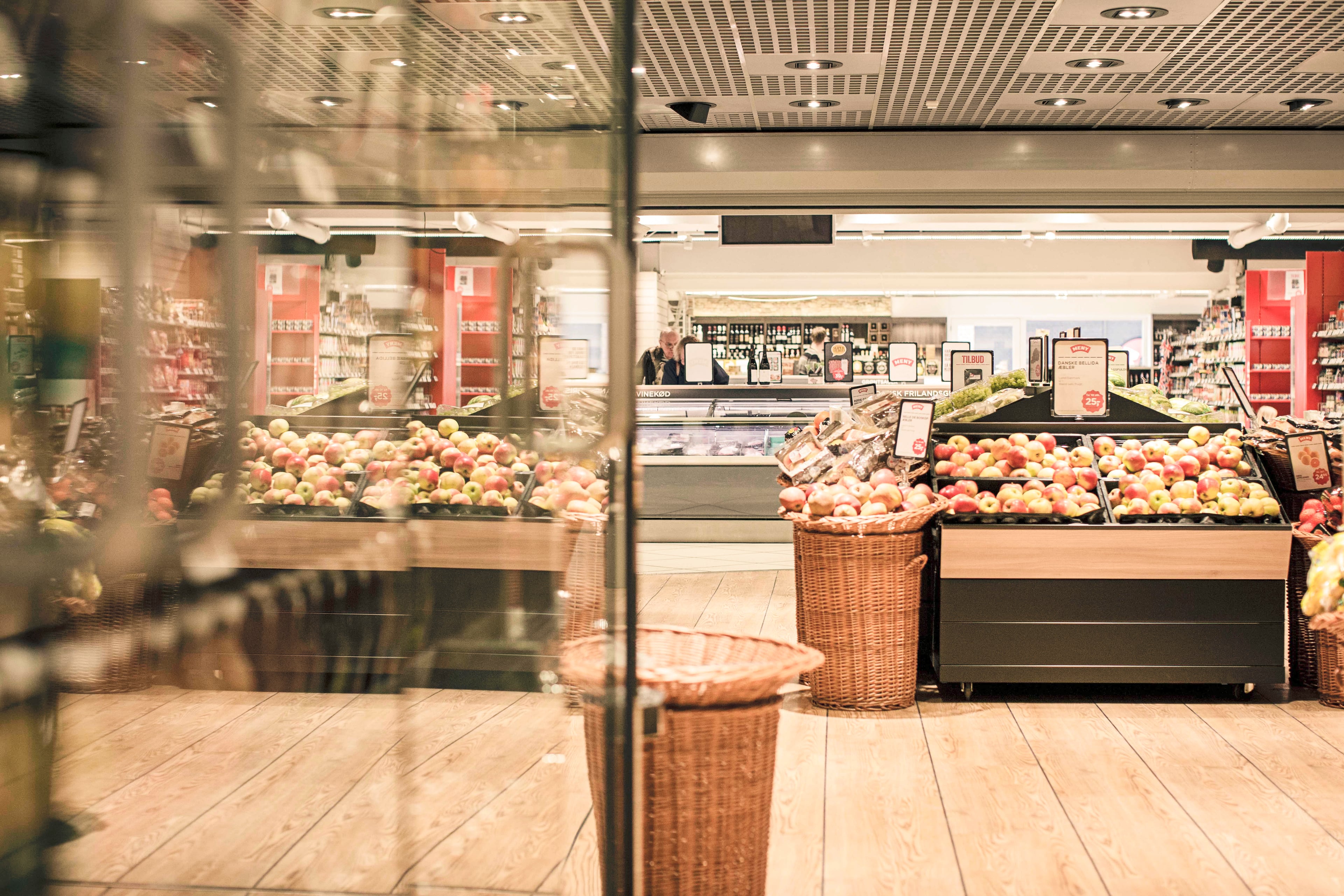 Dagrofa grocery store with fruit and vegetable displays, baskets of apples and onions, counter and shelves