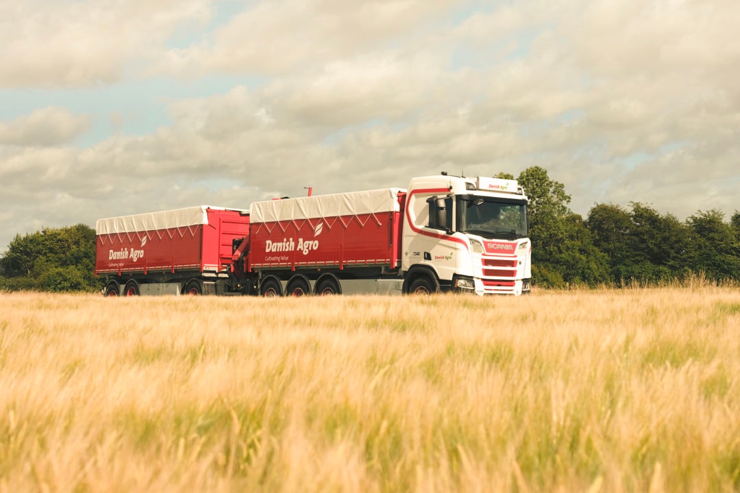 Danish Agro truck with red tipper trailer in grain field